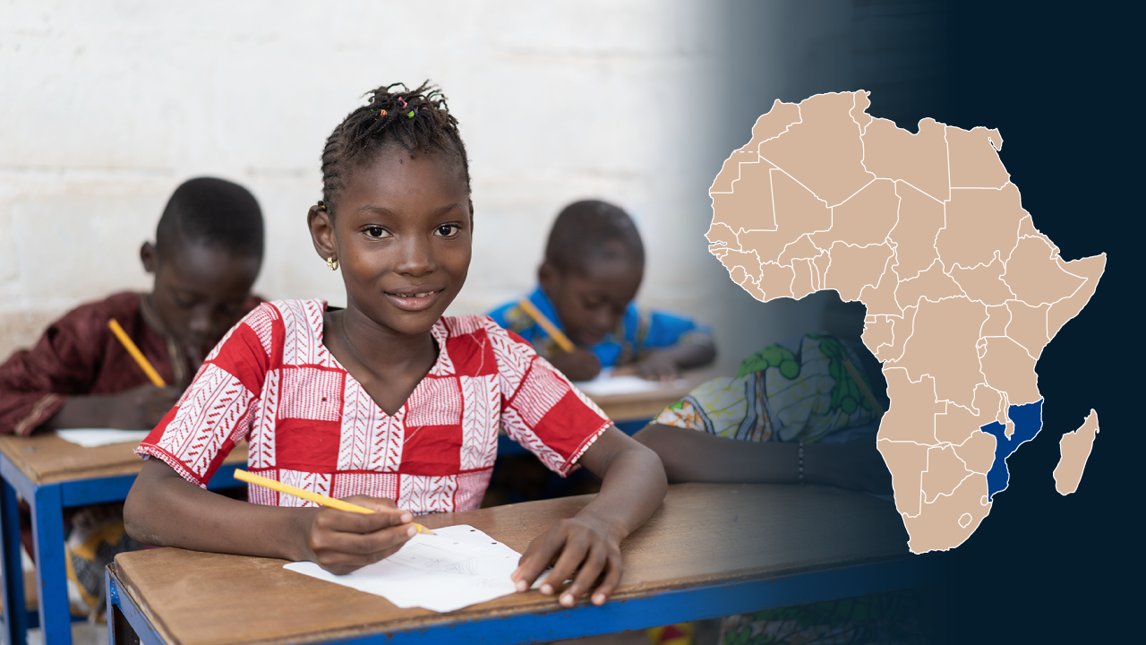 A Mozambican girl is sitting in the classroom. In the picture there is also a map of Africa with Mozambique highlighted on it.